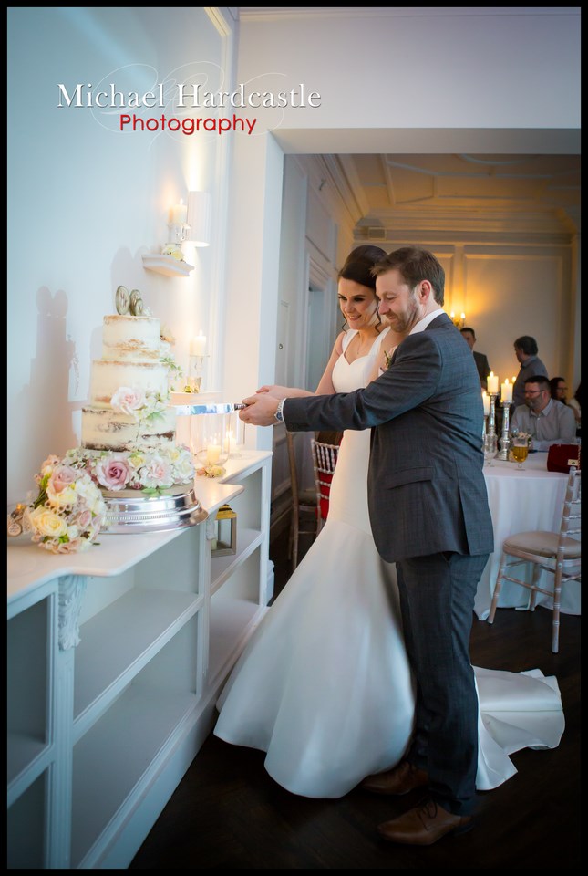 Full length picture of Bride and groom cutting the cake