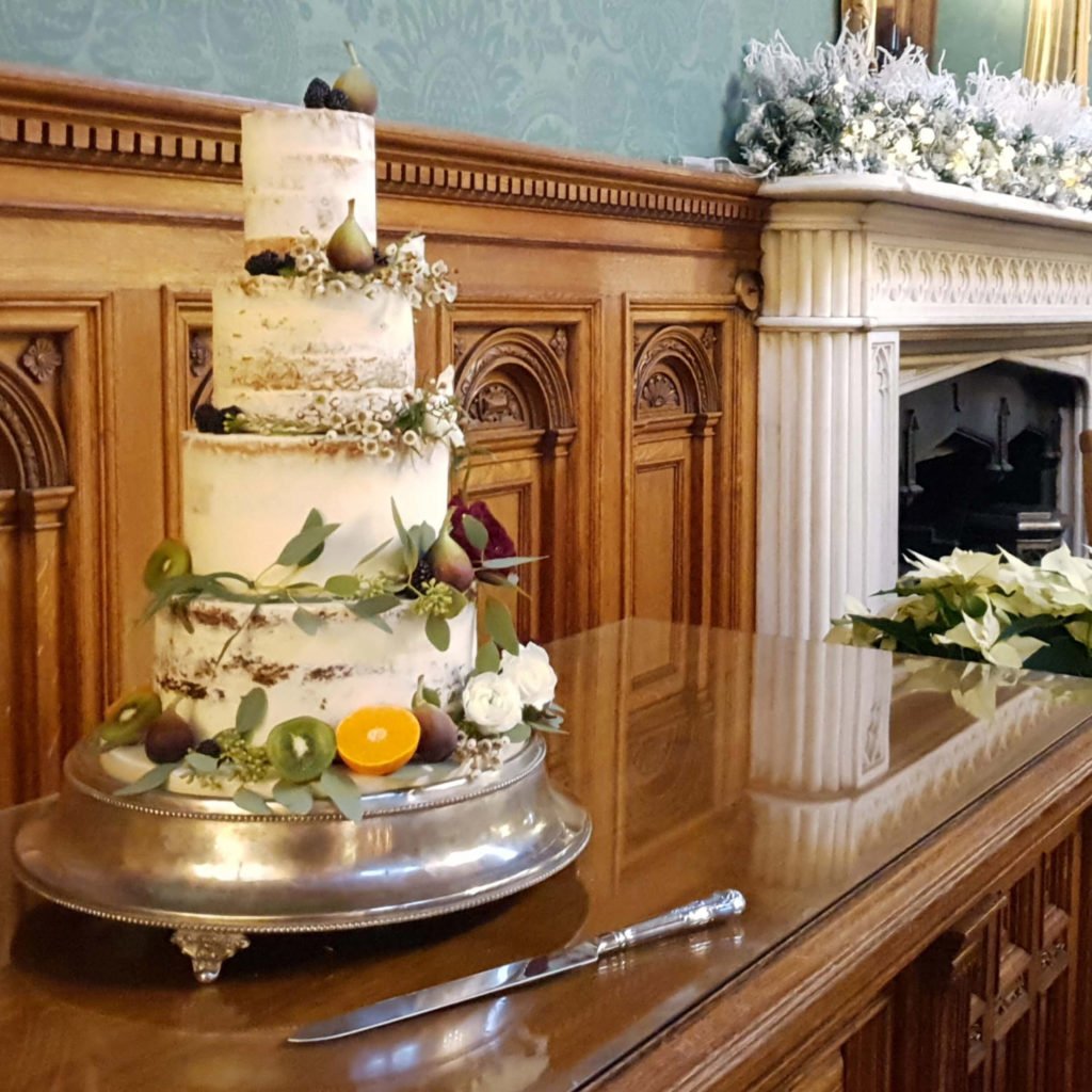 Semi Naked wedding cake dressed with fresh fruit and foliage