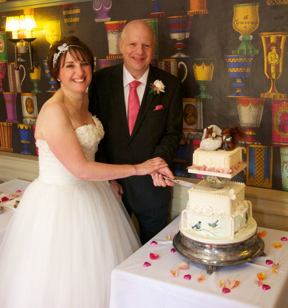 Bride and groom cutting wedding cake