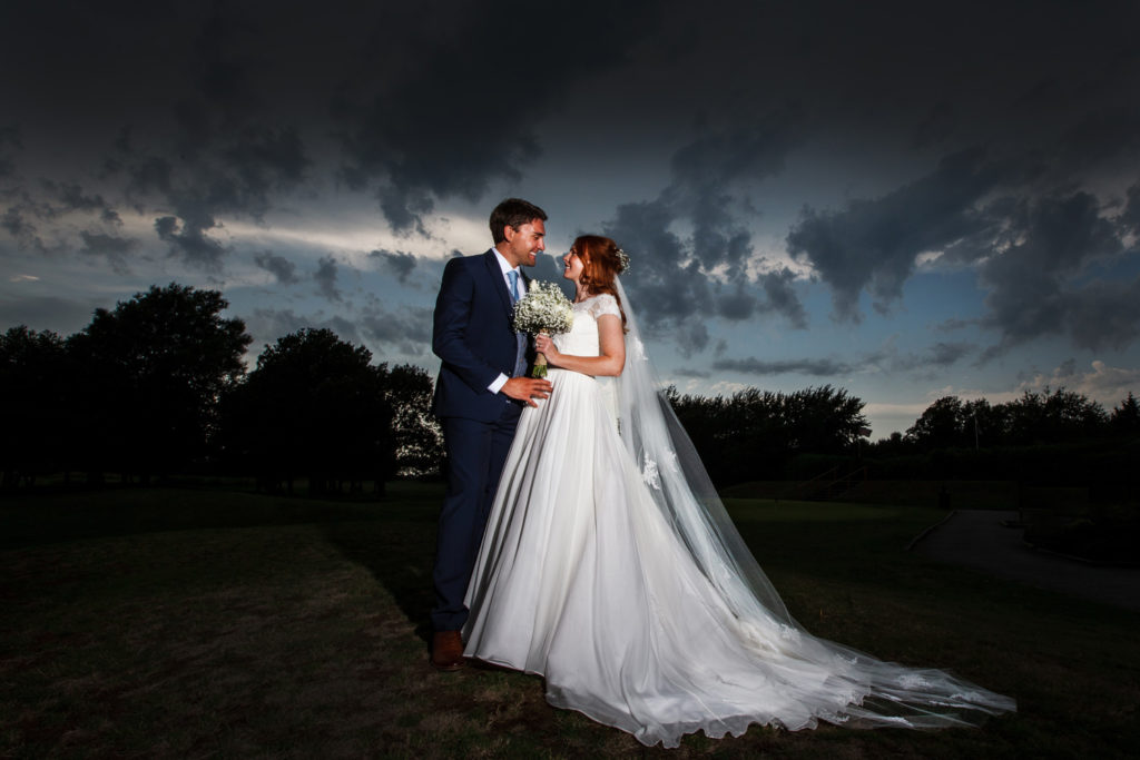 Bride and groom against dramatic thunder clouds