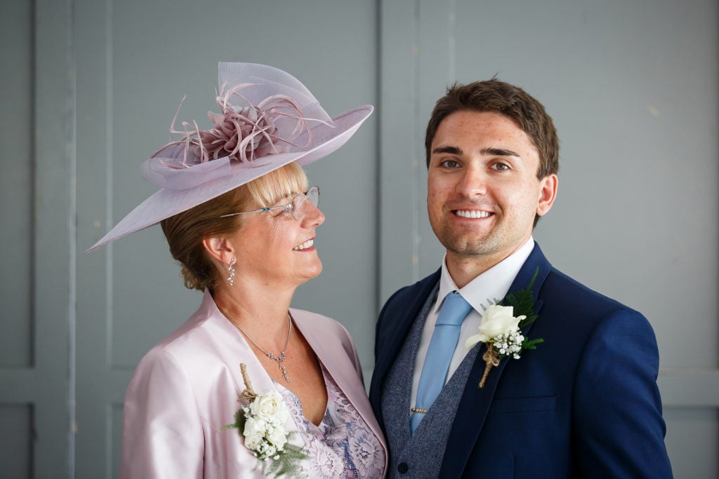 Groom with mother of the groom ivory rose and gypsophila button hole