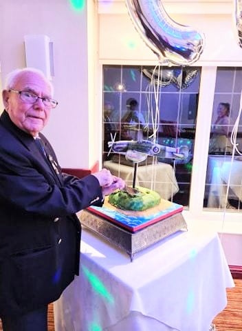 90 year old gentleman cutting his Spitfire cake