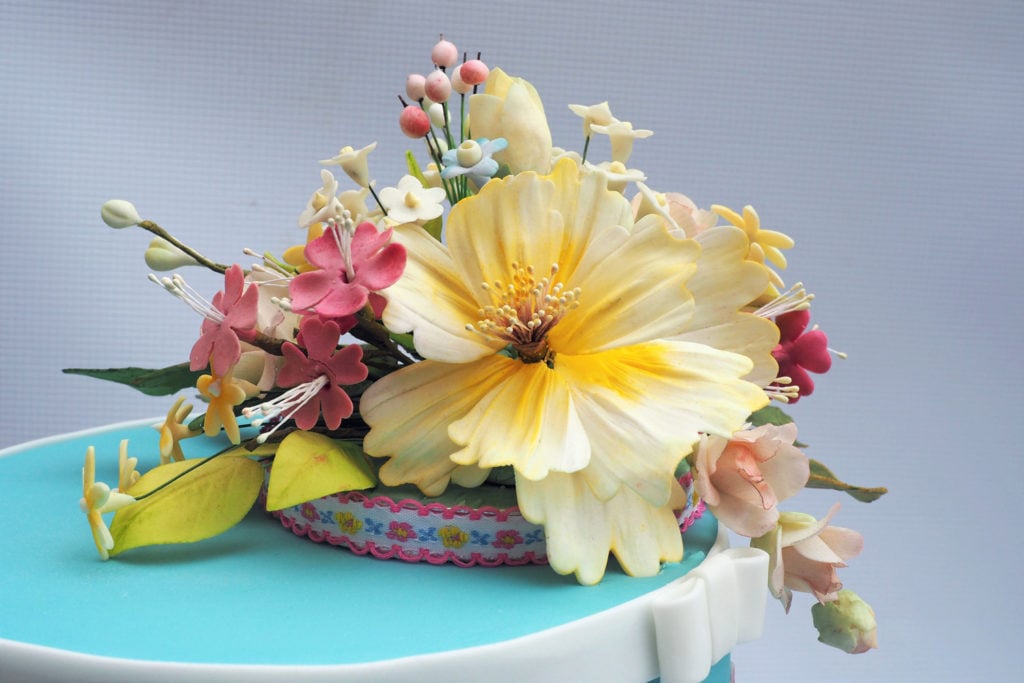 Pretty sugar flowers on an individual ribbon trimmed cake board